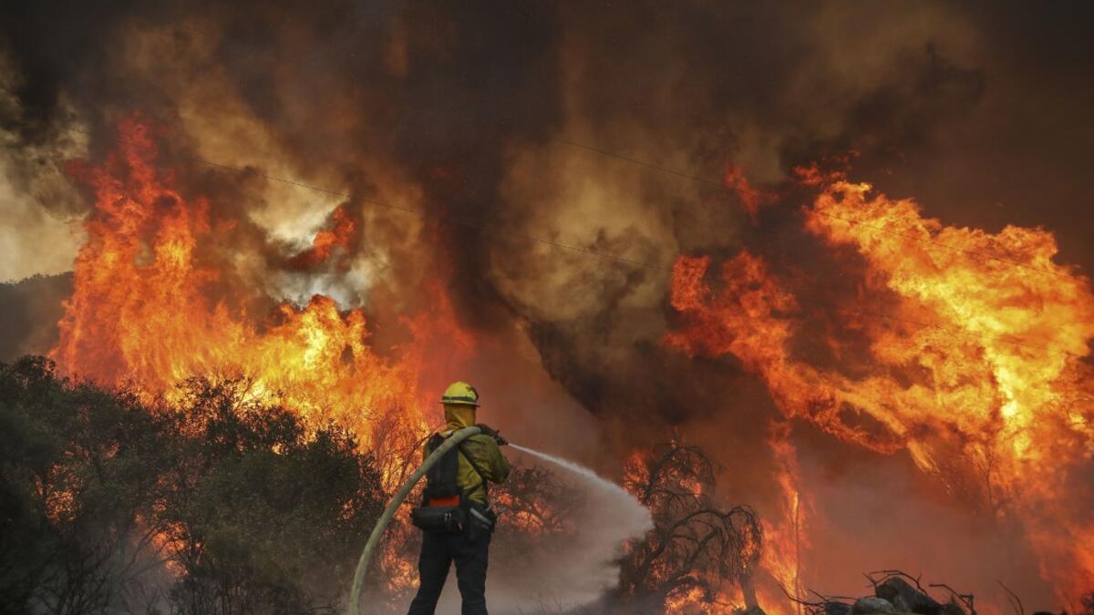 San Miguel County Firefighters battle a brush fire along Japatul Road during the Valley Fire in Jamul, California on September 6, 2020 The Valley Fire in the Japatul Valley burned 4,000 acres overnight with no containment and 10 structures destroyed, Cal Fire San Diego said.  SANDY HUFFAKER / AFP