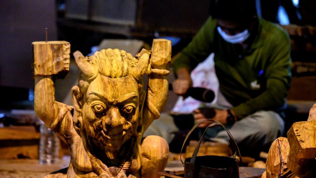 This photograph taken on September 2, 2020 shows workers carving elements for the all wooden Sanctuary of Truth Hindu-Buddhist temple and museum in Pattaya. Mladen ANTONOV / AFP
