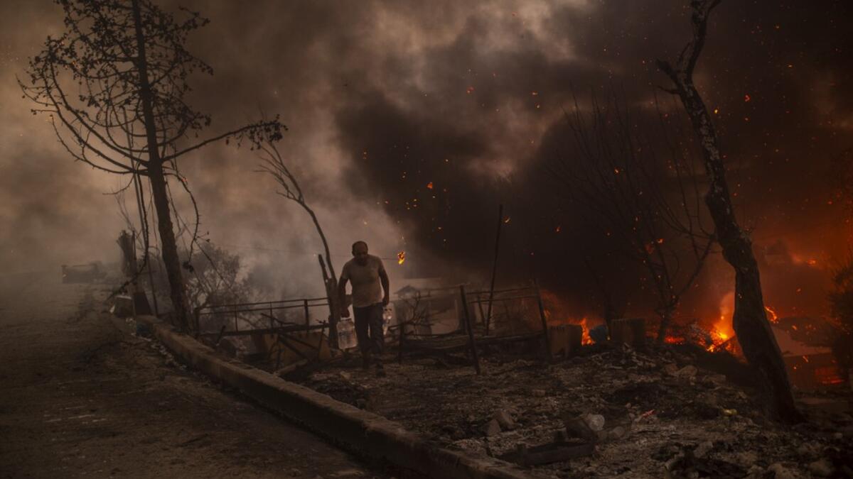 A man carrying belongings flees flames after a major fire broke out in the Moria migrants camp on the Greek Aegean island of Lesbos, on September 9, 2020.