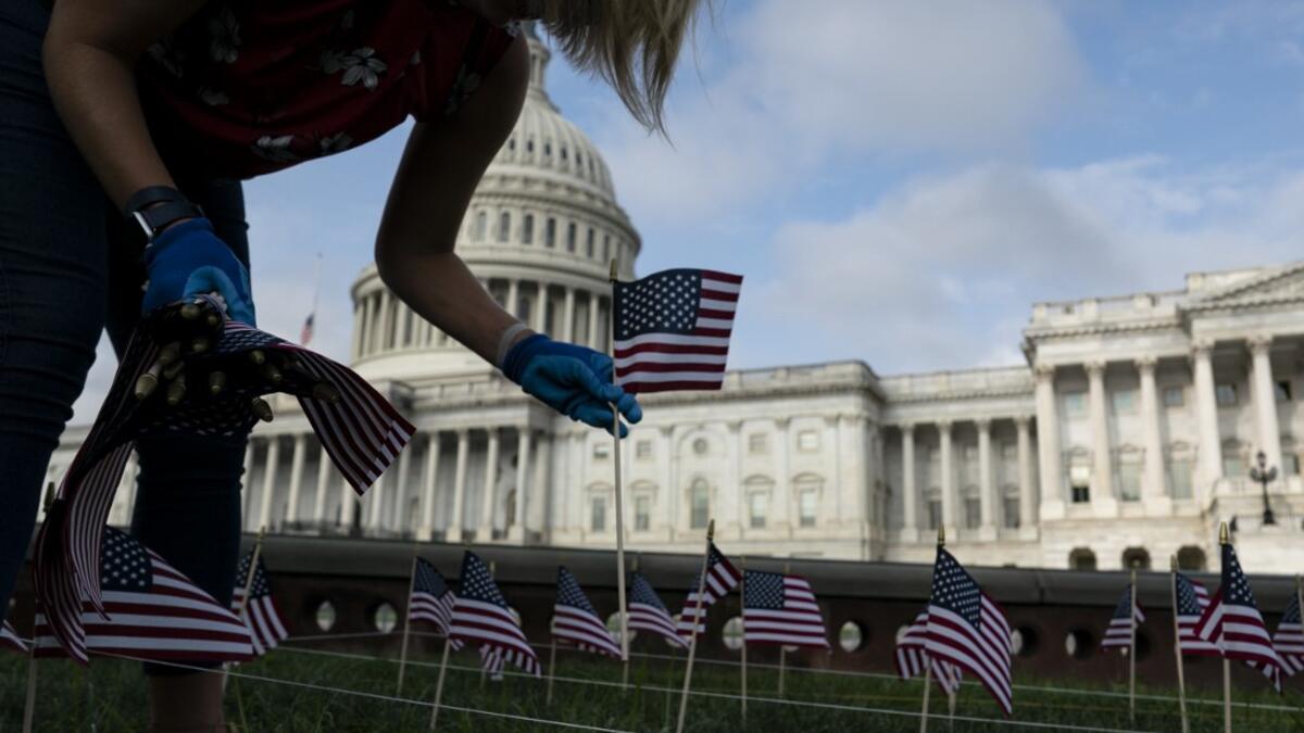 People place US flags in the ground to honor the victims of the 9/11 terrorist attack outside the US Capitol Building on September 11, 2020 in Washington, D.C. Alex Edelman / AFP
