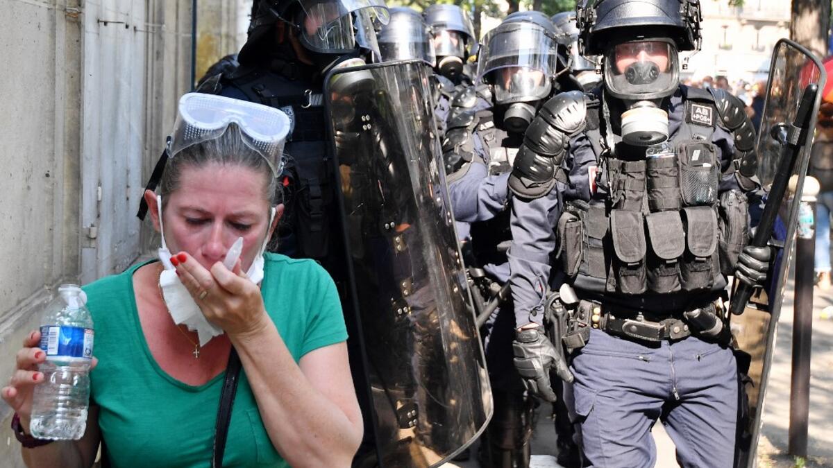 A protester clean her eyes after police fired flee tear gas during a demonstration called by the "yellow vest" (gilets jaunes) movement on September 12, 2020 in Paris. Alain JOCARD / AFP