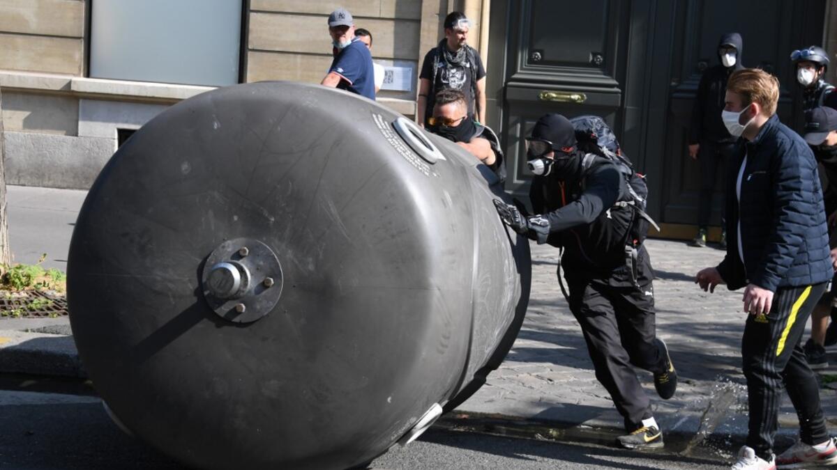 Protesters takes cover after police fired flee tear gas during a demonstration called by the "yellow vest" (gilets jaunes) movement on September 12, 2020 in Paris. Alain JOCARD / AFP