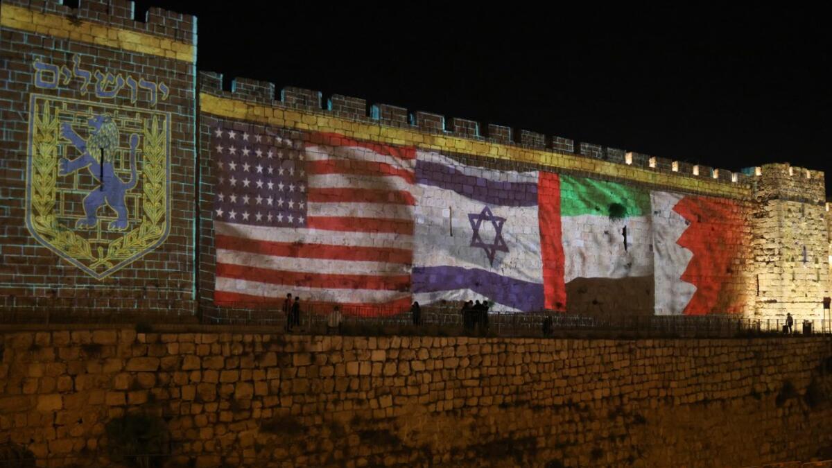 The flags of US, Israel, United Arab Emirates, and Bahrain are projected on the ramparts of Jerusalem's Old City on September 15, 2020 in a show of support for Israeli normalisation deals with the United Arab Emirates and Bahrain. The decision by the UAE and Bahrain to normalise ties with Israel breaks with decades of consensus within the Arab world that a peace deal with the Palestinians is a prerequisite for establishing relations with the Jewish state. Menahem Kahana / AFP