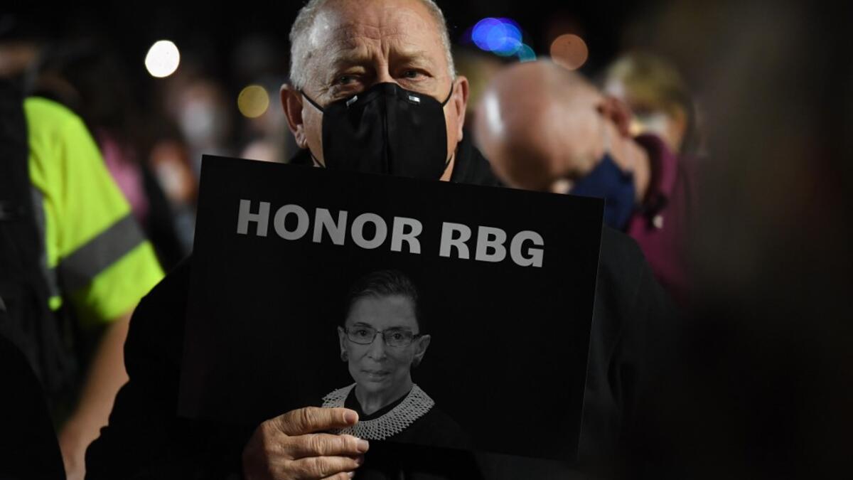 People pay their respects to Ruth Bader Ginsburg near the US Supreme Court in Washington, DC on September 19, 2020. US President Donald Trump vowed to quickly nominate a successor, likely a woman, to replace late Supreme Court Justice Ruth Bader Ginsburg, only a day after the death of the liberal stalwart. Eric BARADAT / AFP