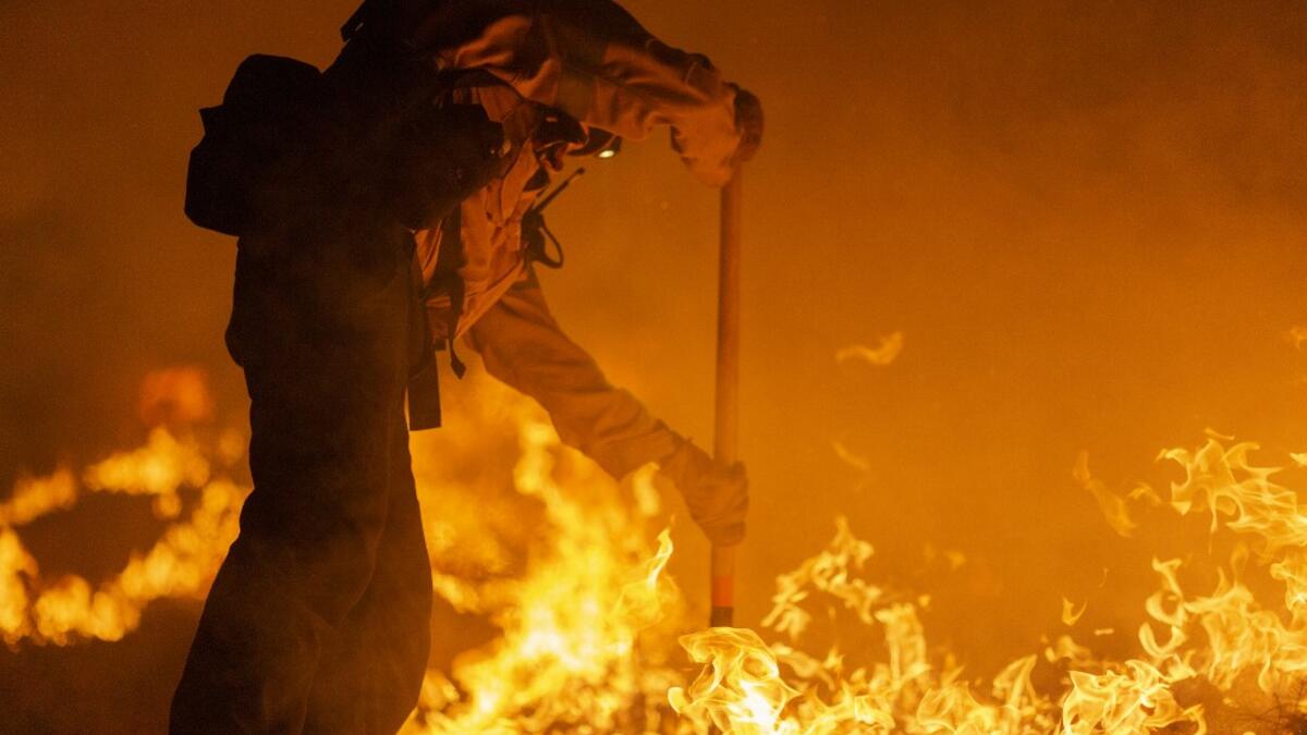 Los Angeles County firefighters, using only hand tools, keep fire from jumping a fire break at the Bobcat Fire in the Angeles National Forest on September 11, 2020 north of Monrovia, California. California wildfires that have already incinerated a record 2.3 million acres this year and are expected to continue till December. The Bobcat Fire has grown to more than 26,000 acres. David McNew/Getty Images/AFP DAVID MCNEW / GETTY IMAGES NORTH AMERICA / Getty Images via AFP
