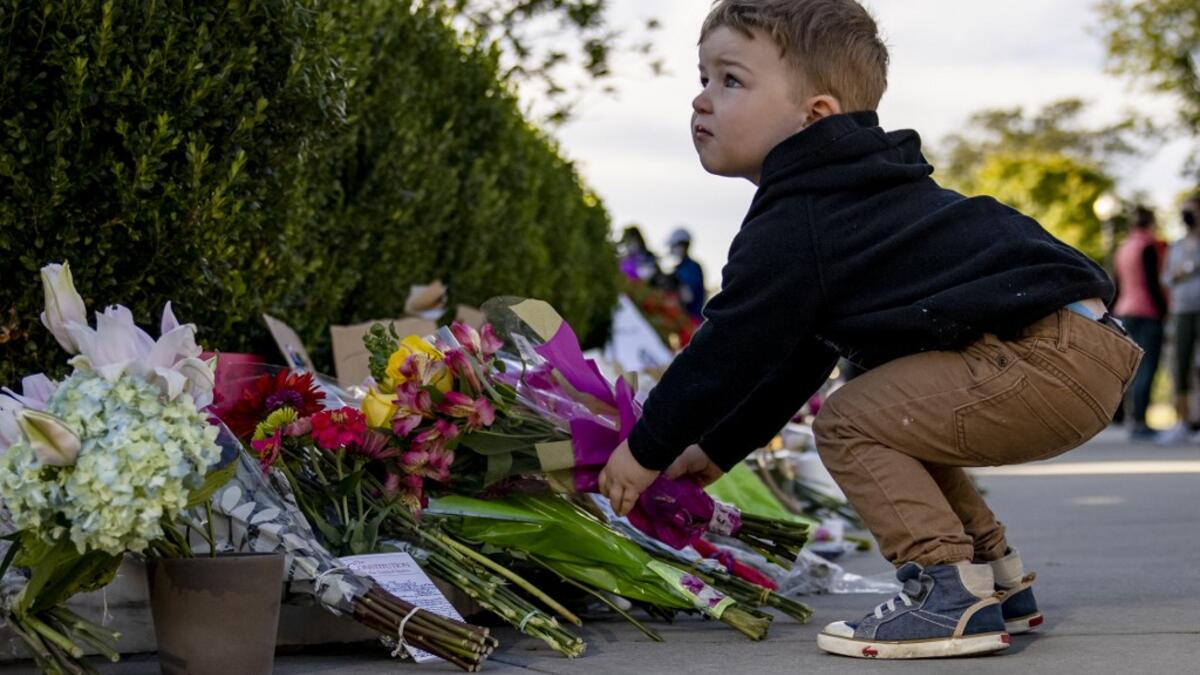 A young boy places flowers at a makeshift memorial in honor of Supreme Court Justice Ruth Bader Ginsburg in front of the US Supreme Court on September 19, 2020 in Washington, DC. Justice Ginsburg has died at age 87 after a battle with pancreatic cancer. Samuel Corum/Getty Images/AFP Samuel Corum / GETTY IMAGES NORTH AMERICA / Getty Images via AFP