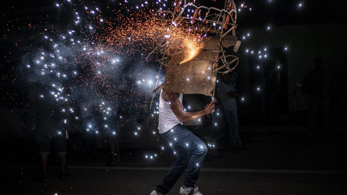 A member of the Afro-Mexican community carries a "toritol" of fire during the annual festival dedicated to San Nicolas Tolentino, in Cuajinicuilapa, Guerrero state, Mexico, on September 9, 2020, amid the COVID-19 coronavirus pandemic. Although there are 1,5 million African descendants in a country of 128 million inhabitants, it is normal to hear that "in Mexico there are no blacks". PEDRO PARDO / AFP