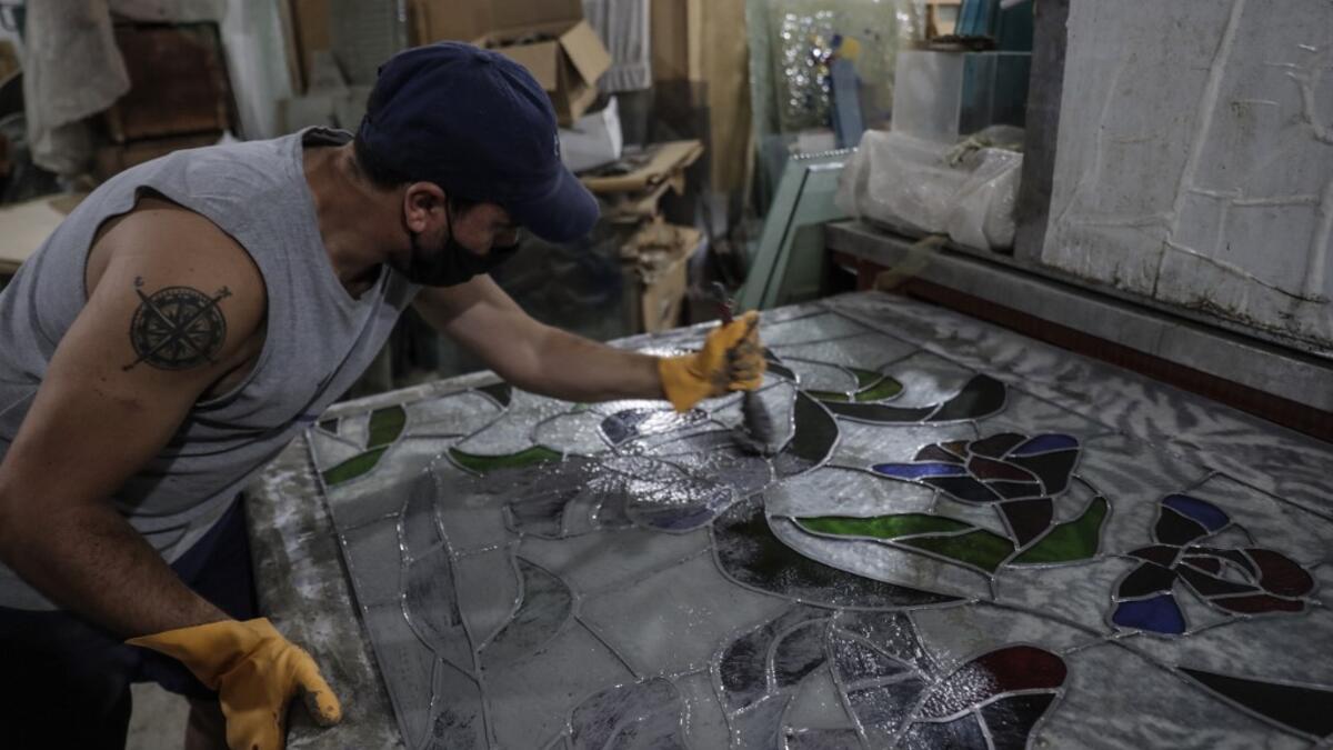 A collaborator of Lebanese stained glass artist Maya Husseini, works on a piece in her basement workshop on the outskirts of the capital Beirut, on September 18, 2020. ANWAR AMRO / AFP