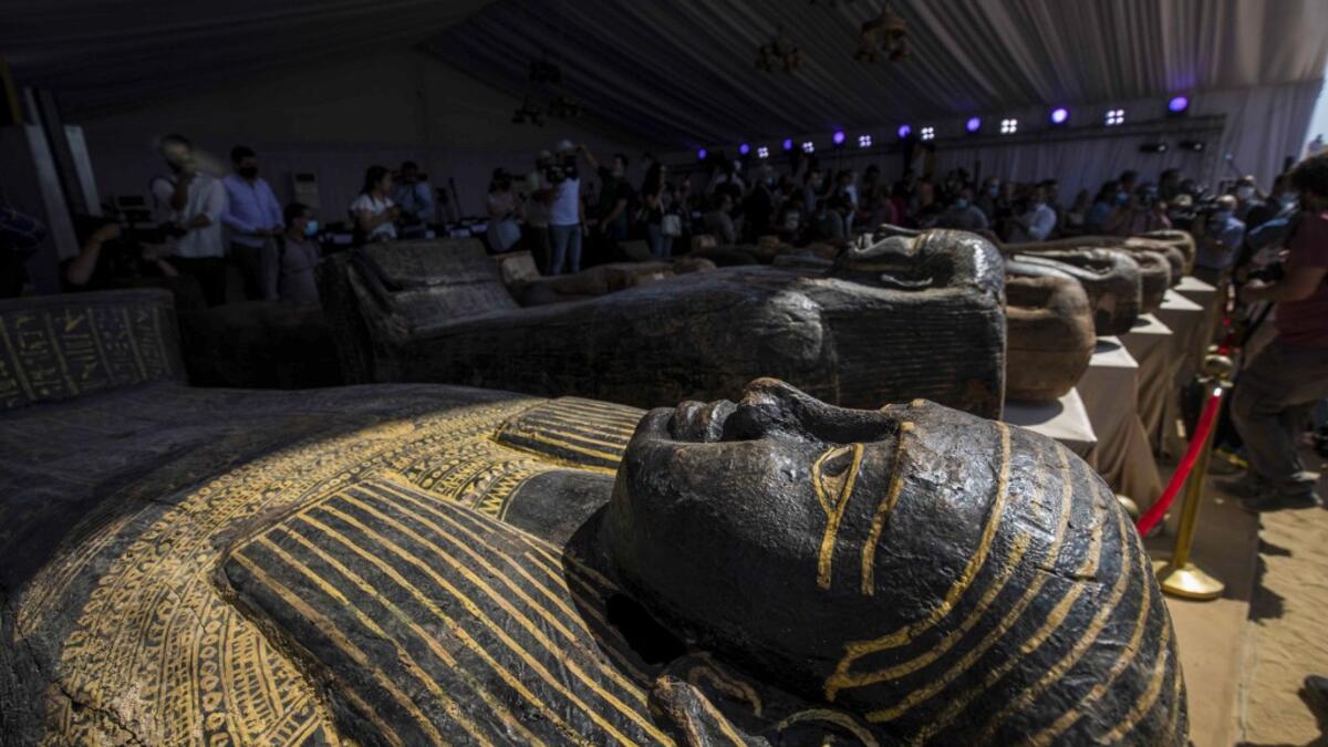 A picture taken on October 3, 2020 shows sarcophaguses, excavated by the Egyptian archaeological mission which discovered a deep burial well with more than 59 human coffins closed for more than 2,500 years, displayed during a press conference at the Saqqara necropolis, 30 kms south of the Egyptian capital Cairo. They were unearthed south of Cairo in the sprawling burial ground of Saqqara, the necropolis of the ancient Egyptian capital of Memphis, a UNESCO World Heritage site. Their exteriors are covered in
