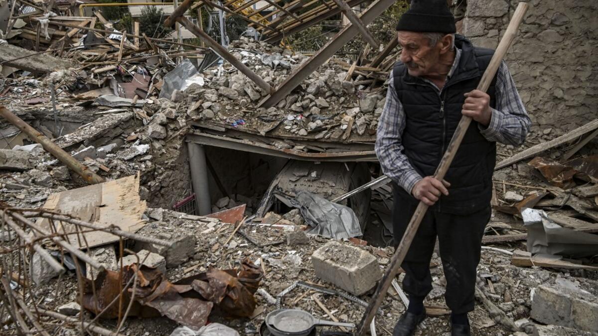 Retired police officer Genadiy Avanesyan, 73, searches for belongings in the remains of his house, which is said was destroyed by Azeri shelling, in the city of Stepanakert on October 10, 2020. Amenia and Azerbaijan traded accusations of new attacks on October 10 in breach of a ceasefire deal to halt nearly two weeks of fierce fighting over the disputed Nagorno-Karabakh region. ARIS MESSINIS / AFP