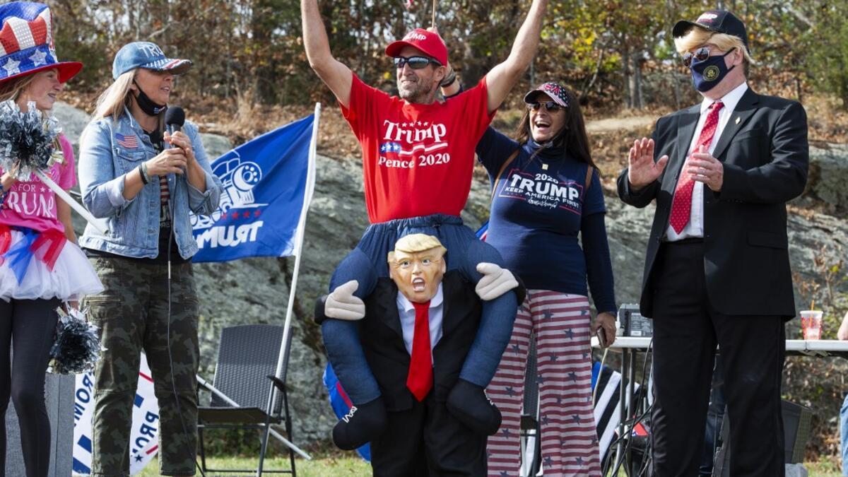 People dressed in political costumes participate in a contest during a Trump campaign rally named "Trumptoberfest" at Rocky Point Park in Warwick, Rhode Island on October 11, 2020. Many supporters dressed in political campaign clothing and waved flags while others dressed in festive costumes to take part in a political costume contest. Joseph Prezioso / AFP