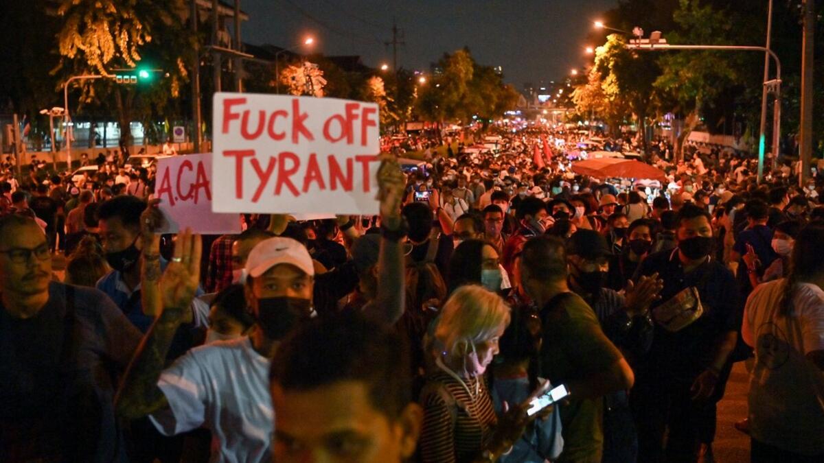 A pro-democracy protester holds up a sign during an anti-government rally next to Government House in Bangkok on October 14, 2020. Mladen ANTONOV / AFP