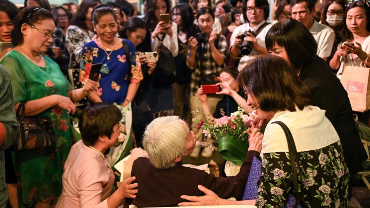 This photograph taken on October 22, 2020 shows guests greeting 89-year-old Vietnamese artist Mong Bich during the opening of her first solo exhibition at the French Cultural Centre in Hanoi. Bich specialises in silk paintings of daily life and ordinary people, women in particular, and ploughed a lonely furrow during many years of war when artists were steered towards the army or frontline workers as subjects. Manan VATSYAYANA / AFP