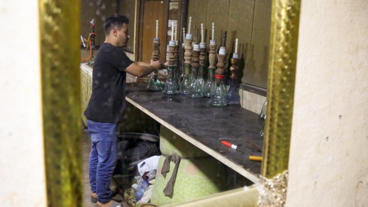 An employee cleans narguilehs (water pipes) at a coffee shop in Iraq's central holy city of Karbala on October 21, 2020. The business of strictly gender-separated cafes has carried on, despite the heavy health risks associated with smoking and a full-blown pandemic that has brought an average of 4,000 new coronavirus cases a day to Iraq. Mohammed SAWAF / AFP