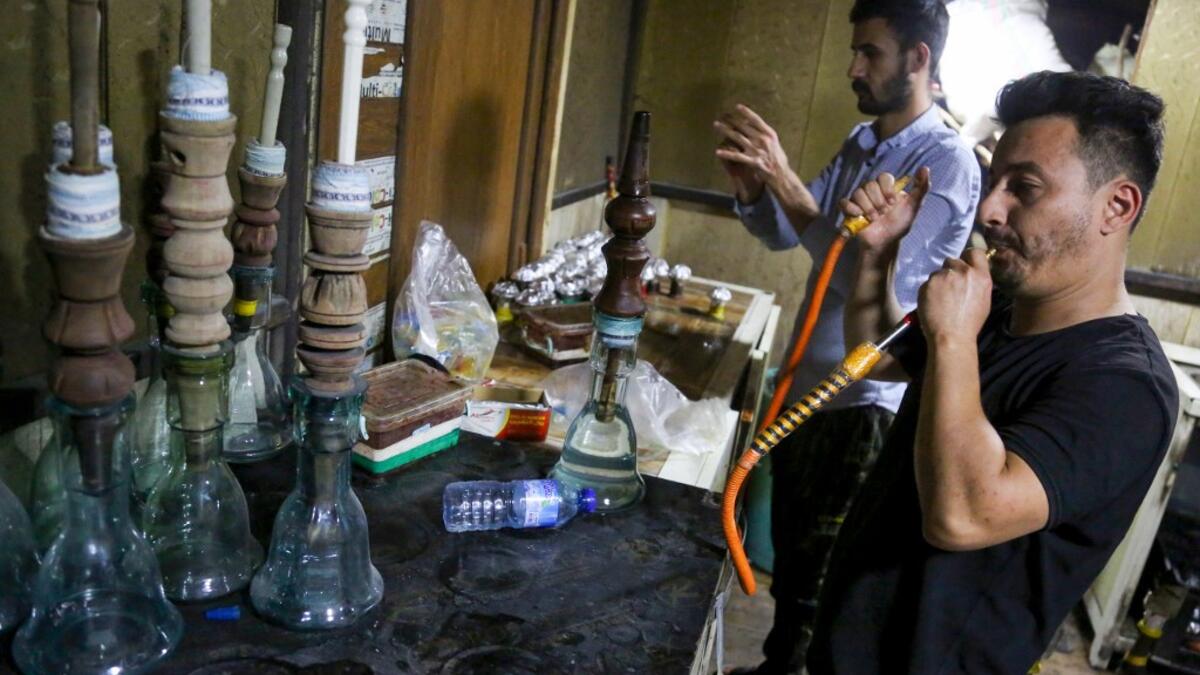 Employees prepare narguilehs (water pipes) for customers at a coffee shop in Iraq's central holy city of Karbala on October 21, 2020. The business of strictly gender-separated cafes has carried on, despite the heavy health risks associated with smoking and a full-blown pandemic that has brought an average of 4,000 new coronavirus cases a day to Iraq. Mohammed SAWAF / AFP