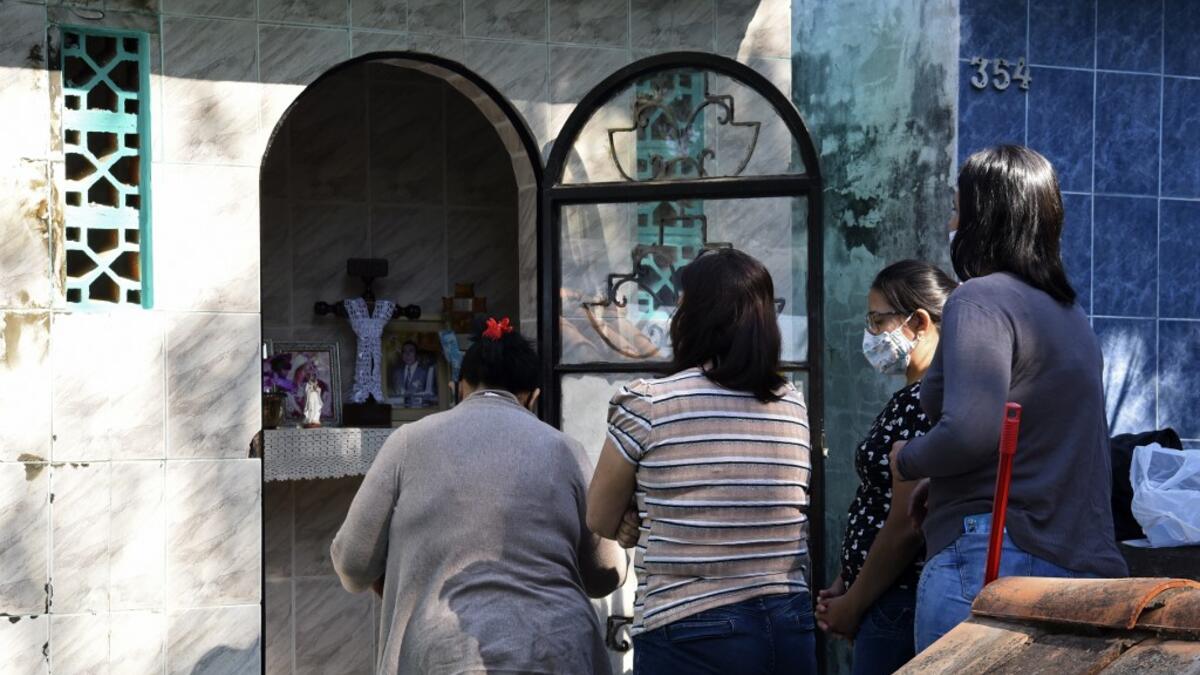 Women visit a relative's tomb at a cemetery in Asuncion on November 1, 2020, on All Saints' Day. Municipal cemeteries in Paraguay will be open to the public only on November 1 and 2, during All Saints' Day and the Day of the Dead, amid the new coronavirus pandemic. NORBERTO DUARTE / AFP