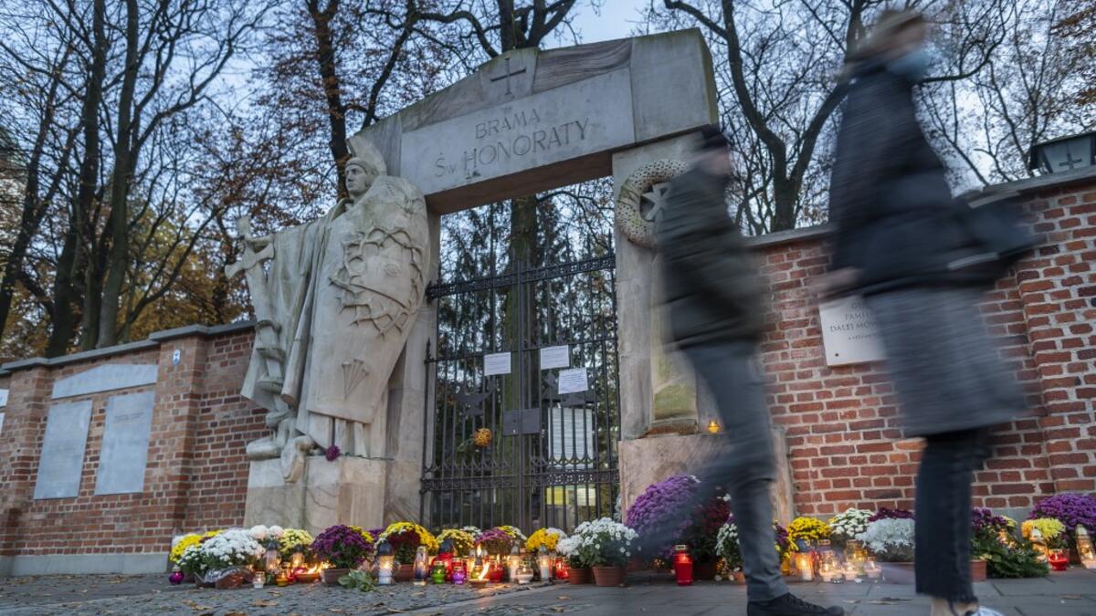 Candles and flowers lay in front of the locked gate to Powazki cementary in Warsaw, Poland, on November 1, 2020, while the polish government closed cemeteries due to COVID-19 restrictions two days before the All Saints' Day, preventing Poles from visiting their loved ones graves according to tradition. The Polish government announced on October 30, 2020 the closure of cemeteries for three days, around All Saints' Day, to curb the outbreak of new contaminations in the country. Wojtek RADWANSKI / AFP