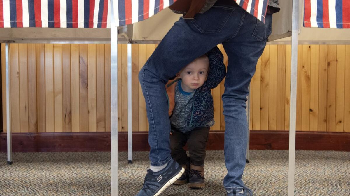 Two-year-old Noah Davenport of Granby, Colorado, waits for his mother to cast her ballot at the Granby Town Hall on November 3, 2020. Americans were voting on Tuesday under the shadow of a surging coronavirus pandemic to decide whether to reelect Republican Donald Trump, one of the most polarizing presidents in US history, or send Democrat Joe Biden to the White House. Jason Connolly / AFP