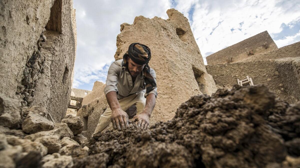 An Egyptian labouror works on the restoration of the fortress of Shali, in the Egyptian desert oasis of Siwa, some 600 kms southwest of the capital Cairo, on November 5, 2020. The 13th century edifice, called Shali or "Home" in the Siwi language, was built by Berber populations, using kershef, a mixture of clay, salt and rock which acts as a natural insulator in an area where the summer heat can be scorching. Khaled DESOUKI / AFP