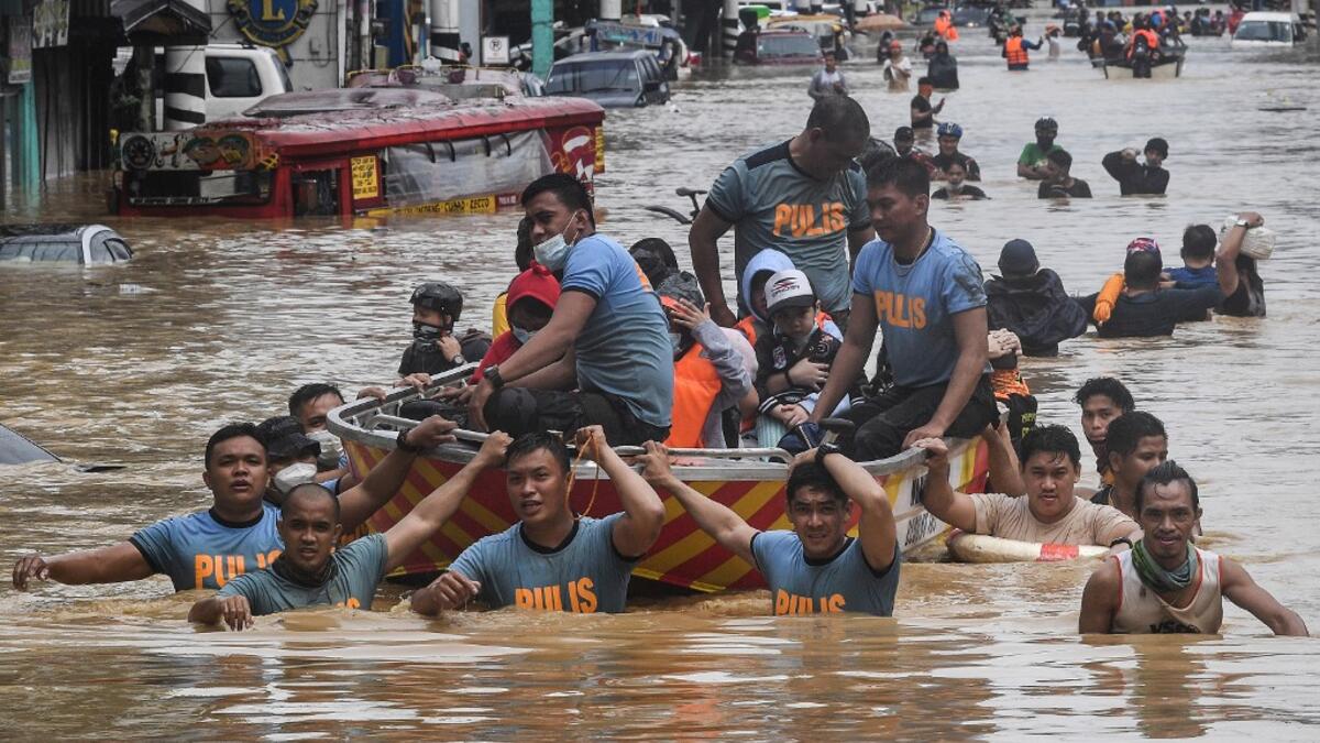 Rescuers pull a rubber boat carrying residents through a flooded street after Typhoon Vamco hit in Marikina City, suburban Manila on November 12, 2020. Ted ALJIBE / AFP