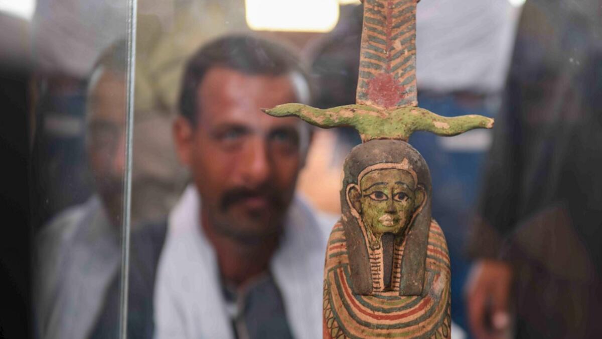 A picture shows a statue on display during the unveiling of an ancient treasure trove of more than a 100 intact sarcophagi, at the Saqqara necropolis 30 kms south of the Egyptian capital Cairo, on November 14, 2020. Egypt announced the discovery of an ancient treasure trove of more than a 100 intact sarcophagi, the largest such find this year. The sealed wooden coffins, unveiled on site amid fanfare, belonged to top officials of the Late Period and the Ptolemaic period of ancient Egypt. They were found in t