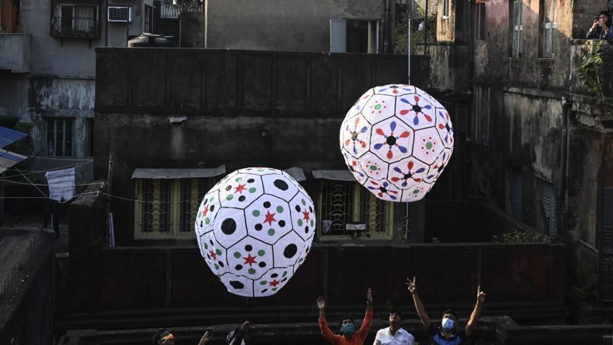 Revellers release handmade sky-lanterns from the terrace of a building to celebrate Diwali, the Hindu festival of lights, in Kolkata on November 14, 2020. Dibyangshu SARKAR / AFP