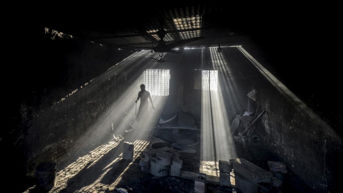 In this picture taken on November 12, 2020 a dockyard worker makes a propeller of a ship on the banks of the Buriganga River in Char Kaliganj on the outskirts of Dhaka. Rivers are the lifeblood of the delta nation of 168 million people where much of the low-lying land is accessed via boat, with Bangladesh's strong economic growth of recent years fuelling more investments in new and bigger ships. Munir UZ ZAMAN / AFP