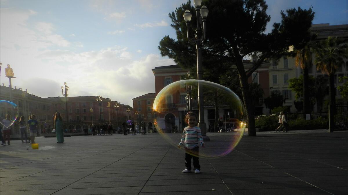 A small girl playing with soap bubble in the downtown of Nice, in the French Riviera /Photo by Ewelina Lepionko