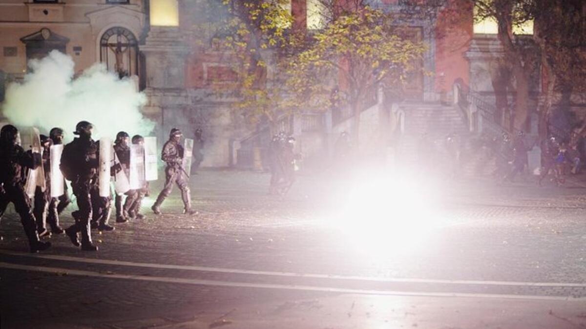 Protesters run through tear gas as they clash with police during the rally against government’s coronavirus restrictions in Ljubljana on November 5, 2020.