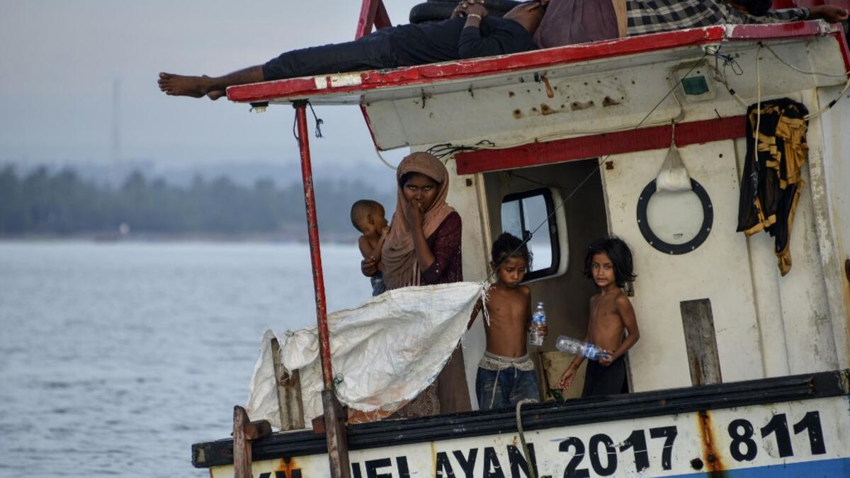 This photo taken on June 25, 2020 shows six-year-old Nosmin Fatima (R) with other Rohingya migrants as they arrive in Lhokseumawe in North Aceh. Weeks after a funeral for the wife and daughter he thought had died at sea while trying to sail to him, Nemah Shah was stunned when he saw online images of them emerging from a refugee boat in Indonesia.  CHAIDEER MAHYUDDIN / AFP
