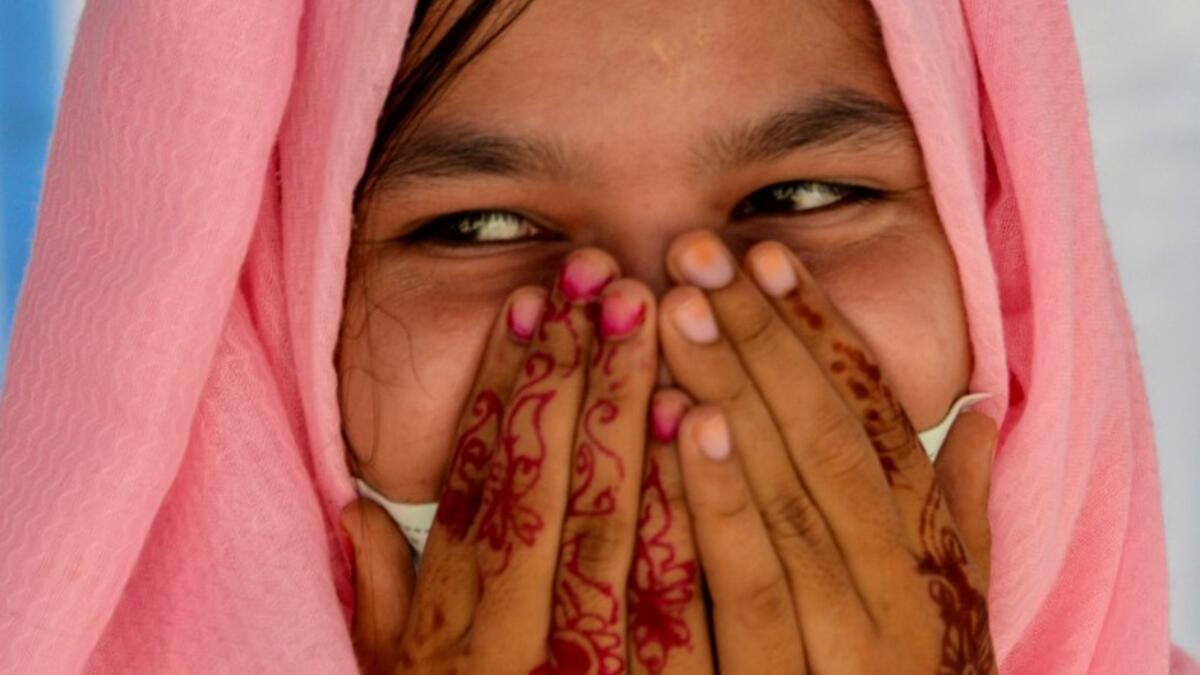 This photo taken on October 21, 2020 shows Rohingya refugee Amerah, 18, who said she has not seen her fiance -- who is a construction worker in Malaysia -- since she was six, at a temporary shelter in Lhokseumawe in Aceh province. Stay in a squalid refugee camp -- hopeless, starving, and made to feel a burden -- or leave, risking death, rape, human trafficking and months at sea to reach a husband you've never met. This is the bleak choice many Rohingya women, already scarred from fleeing persecution in Myan