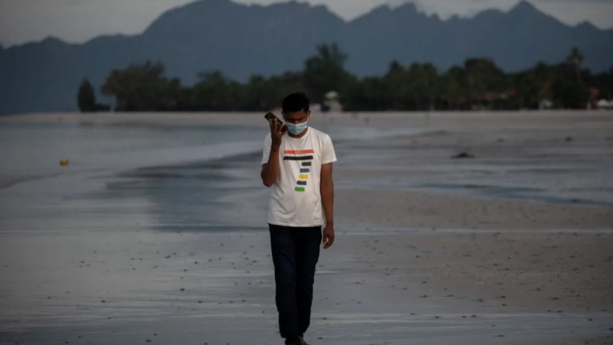 This picture taken on November 16, 2020 shows Rohingya refugee "Abdu Hamid" (using a pseudonym) holding his mobile phone on the Malaysian island of Langkawi, during a video call with his wife who is living at the Kutupalong refugee camp in Ukhia in southern Bangladesh. The video-call app they used to get married in 2017 remains the only means of contact for Julekha and her husband, Abdu Hamid, a Rohingya hotel worker. Mohd RASFAN / AFP