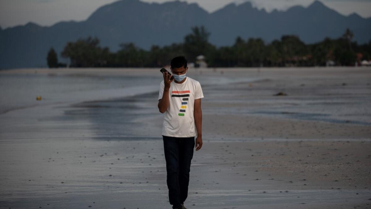This picture taken on November 16, 2020 shows Rohingya refugee "Abdu Hamid" (using a pseudonym) holding his mobile phone on the Malaysian island of Langkawi, during a video call with his wife who is living at the Kutupalong refugee camp in Ukhia in southern Bangladesh. The video-call app they used to get married in 2017 remains the only means of contact for Julekha and her husband, Abdu Hamid, a Rohingya hotel worker. Mohd RASFAN / AFP