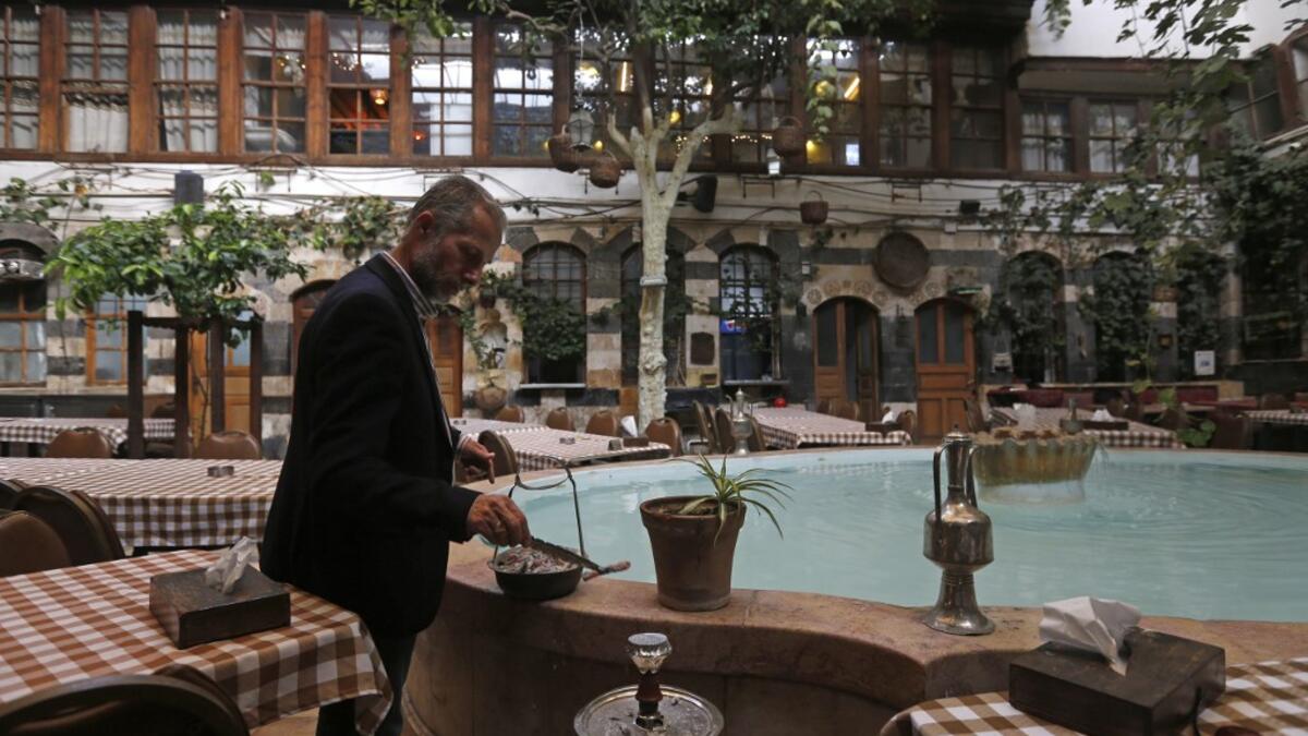 Raed al-Jabri, 61-year-old Syrian, works inside his home-turned-restaurant in the old part of Syria's capital Damascus on November 10, 2020. LOUAI BESHARA / AFP