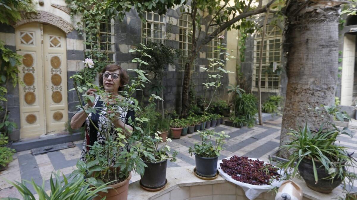 Nahida Mabardi takes care of her heritage house in the old part of Syria's capital Damascus on October 28, 2020. The old city of the Syrian capital is famed for its elegant century-old houses, usually two storeys built around a leafy rectangular courtyard with a carved stone fountain at its centre. While the capital has been largely spared the violence of Syria's almost ten-year war, several of these traditional homes have been abandoned by their owners or damaged in the conflict. LOUAI BESHARA / AFP