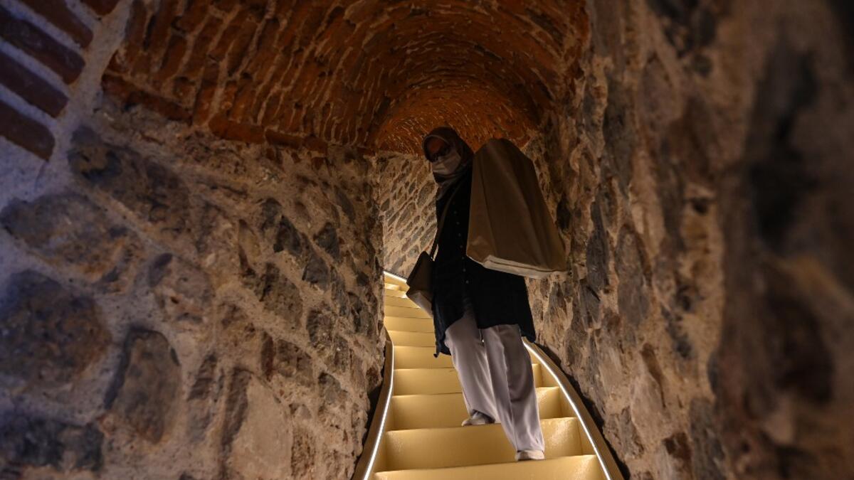 A woman walks upstairs after the restoration of the Galata Tower on October 16, 2020 in Istanbul. The Galata Tower -- an emblematic 14th century monument of Istanbul -- has become the latest victim of such controversy. Ozan KOSE / AFP