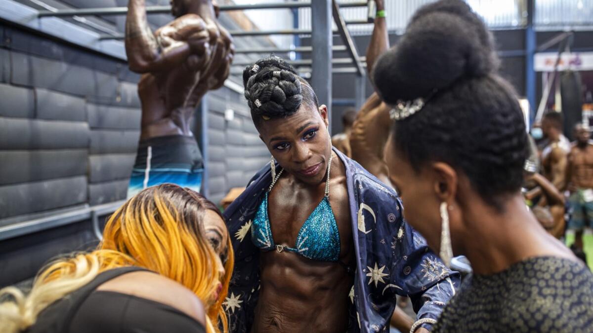 Bodybuilders gather in the backstage warming up area before taking aprt in the Iron Fit Bodybuilding competition in Nairobi on December 05, 2020. 130 participants from all across East Africa took part in the second edition of this competition which included categories like Bikini, Figure, Physique and Bodybuilding. Patrick Meinhardt / AFP