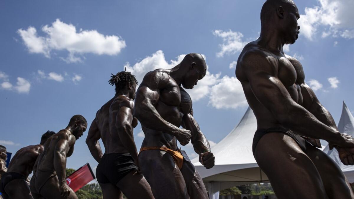 Bodybuilders pose on stage during the Iron Fit Bodybuilding competition in Nairobi on December 05, 2020. 130 participants from all across East Africa took part in the second edition of this competition which included categories like Bikini, Figure, Physique and Bodybuilding. Patrick Meinhardt / AFP