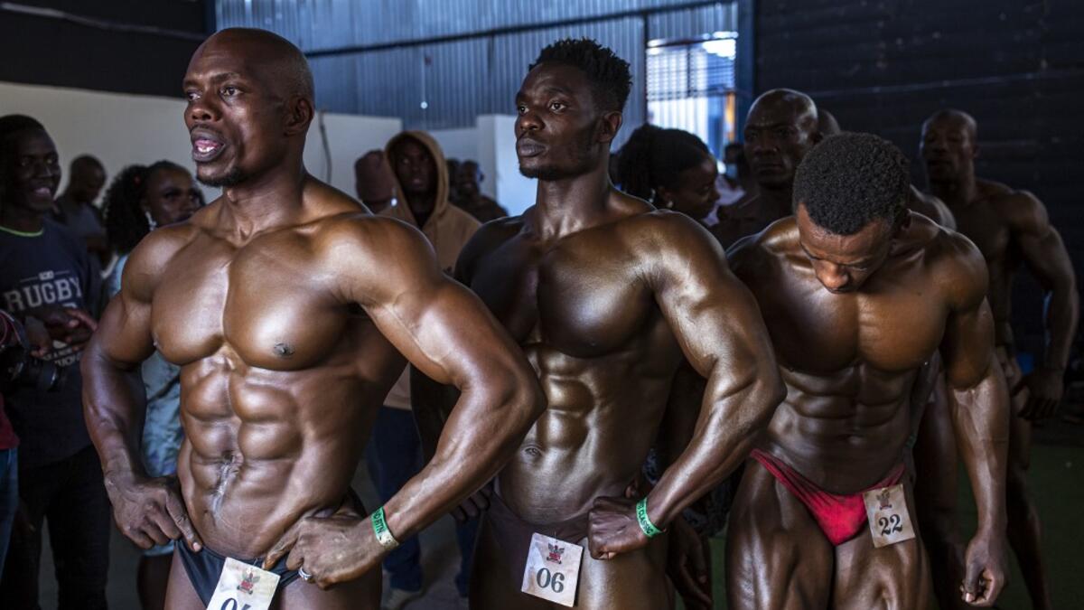 Bodybuilders wait before going on stage during the Iron Fit Bodybuilding competition in Nairobi on December 05, 2020. 130 participants from all across East Africa took part in the second edition of this competition which included categories like Bikini, Figure, Physique and Bodybuilding. Patrick Meinhardt / AFP
