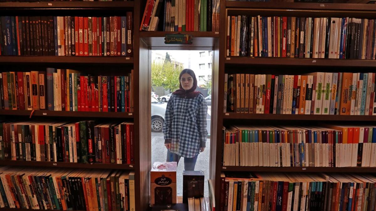 Employee Sepideh Daryan poses for a picture at a bookstore of the Nashre-Cheshmeh Publishing House in the Iranian capital Tehran, on December 5, 2020. ATTA KENARE / AFP