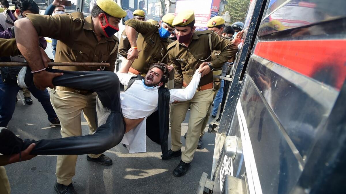 Policemen detain a student leader during a protest in support of the nationwide general strike called by farmers against the recent agricultural reforms in Allahabad on December 8, 2020. SANJAY KANOJIA / AFP