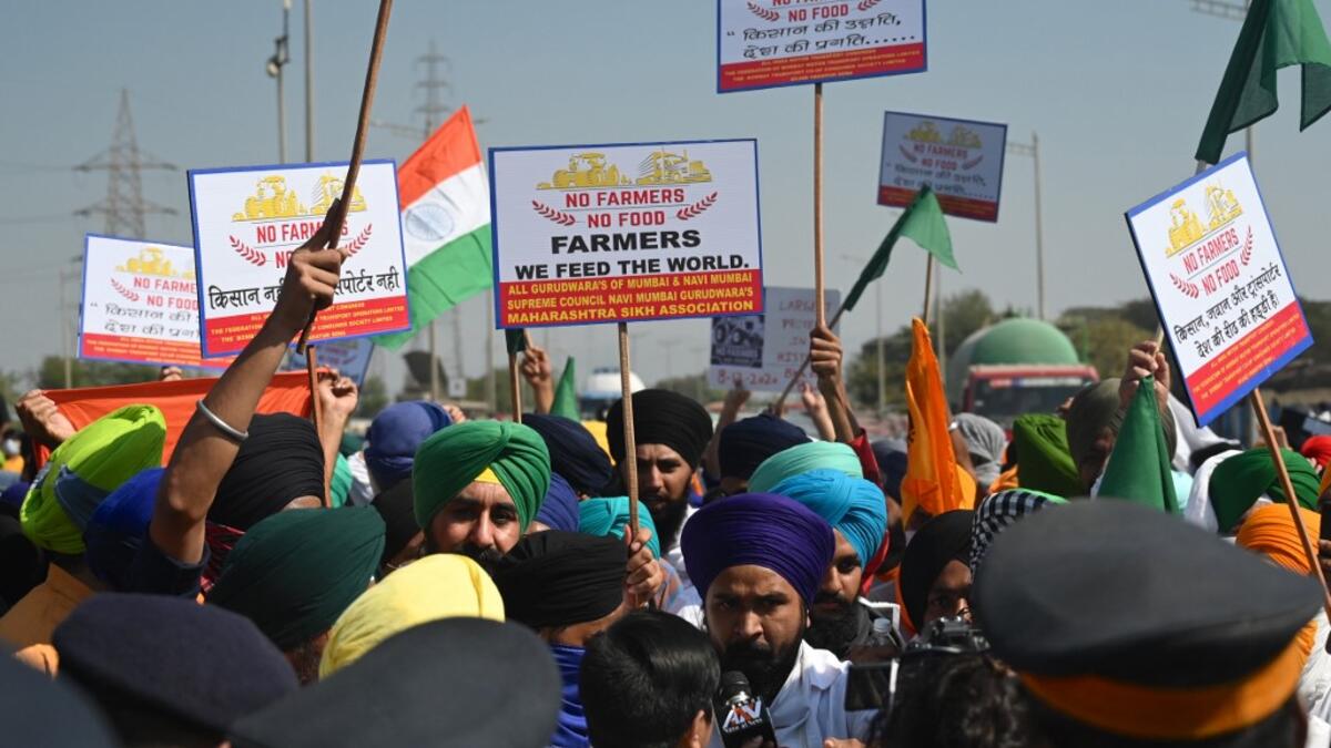 Protesters holding posters argue with policemen while blocking a highway during a nationwide general strike called by farmers to protest against the recent agricultural reforms in Mumbai on December 8, 2020. Indranil MUKHERJEE / AFP
