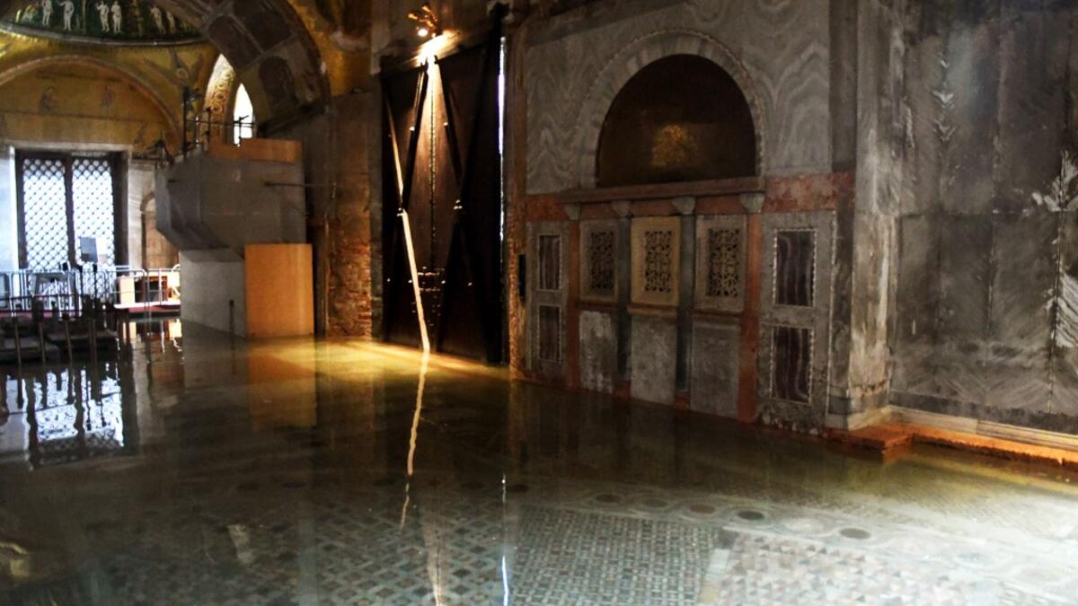 A view shows the flooded entrance of St. Mark's Basilica on December 8, 2020 in Venice following a high tide "Alta Acqua" event following heavy rains and strong winds, and the mobile gates of the MOSE Experimental Electromechanical Module that protects the city of Venice from floods, were not lifted ANDREA PATTARO / AFP