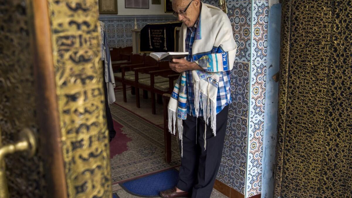 In this file photo taken on October 13, 2017, Moroccan Jews and Israeli Jewish tourists participate in a religious ceremony to observe the holiday of Sukkot (the Feast of the Tabernacles) at a synagogue in the "Mellah" Jewish quarter of the Medina in Marrakesh. Jewish history and culture in Morocco will now be part of the school curriculum -- a "first" in the region and in the North African country, where Islam is the state religion. Morocco's Jewish community has been present since antiquity and grew over