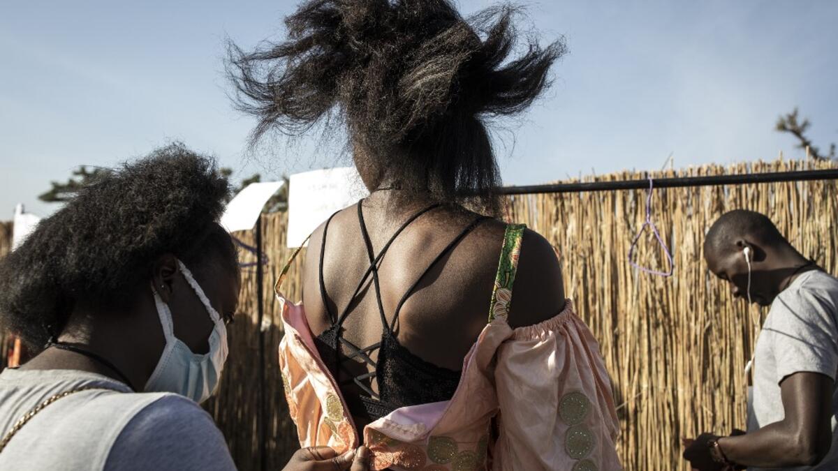 A fashion model gets a dress fitted ahead of the start of Dakar Fashion Week in Dakar on December 12, 2020. JOHN WESSELS / AFP