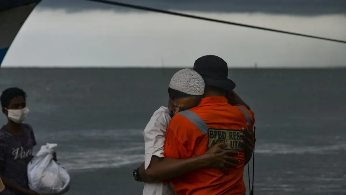 Rohingya migrant hugs an Indonesian officer after a boat carrying other migrants made landing by the shores of Lancok village, in Indonesia's North Aceh Regency. Boatloads of Rohingya landing across Southeast Asia are victims of complex human trafficking networks run by a dizzying web of players, from crime bosses and corrupt cops to poor fishermen, rickshaw drivers and even Rohingya themselves. CHAIDEER MAHYUDDIN / AFP