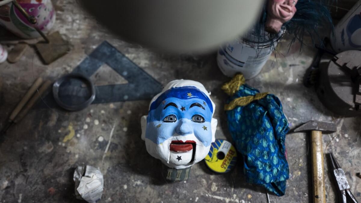 A puppet head lies on a workbench at the " Alfa Theatre" laboratory in Turin, on November 30, 2020. The Grilli family has a collection of more than 20,000 objects from around the world, everything from theatres, marionettes and glove puppets to shadow figures and silhouettes. A long-time dream of Grilli and his wife Mariarosa, 78, the museum is due to open in 2023 in Turin, financed both privately and publicly with the help of different institutions.  Marco Bertorello / AFP