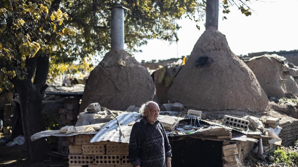 Syrian-Armenian potter Misak Antranik Petros walks outside his workshop located inside an ancient mud-brick house near the city of Qamishli in Syria's northeastern Hasakeh province, on December 19, 2020. Petros was only a teenager when he had to take over for his sick father and become the main potter of the family. He has since become a master of the craft, and is keen to pass his skills on.  Delil SOULEIMAN / AFP