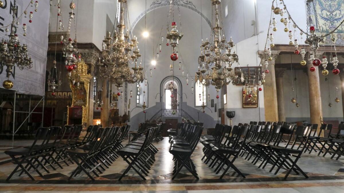 Empty chairs are pictured during Sunday mass in the Church of the Nativity, in the West Bank city of Bethlehem, on December 20, 2020 after it was re-opened for prayers following strict COVID-19 restrictions. HAZEM BADER / AFP
