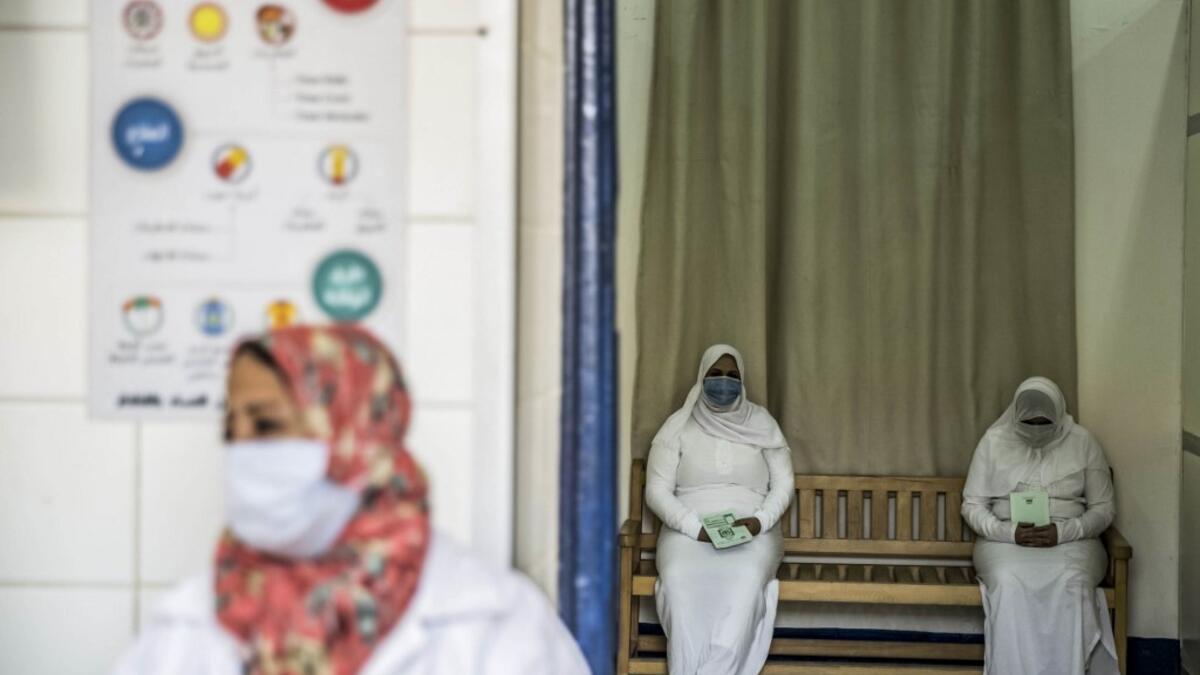 This picture taken during a government-guided tour on December 27, 2020 shows inmates, mask-clad due to the COVID-19 coronavirus pandemic, waiting at the outpatient clinic at al-Qanatir women's prison, at the tip of the Nile delta in Qalyoubiya province, about 30 kilometres north of Egypt's capital. Khaled DESOUKI / AFP